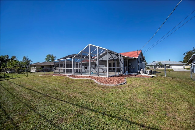 rear view of property with a yard and glass enclosure