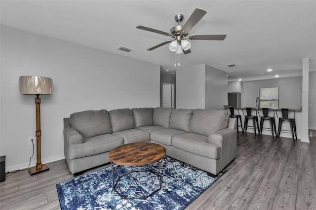 living room with ceiling fan and hardwood / wood-style flooring