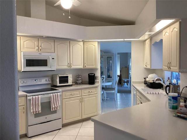 kitchen with white appliances, ceiling fan, sink, lofted ceiling, and light tile patterned flooring