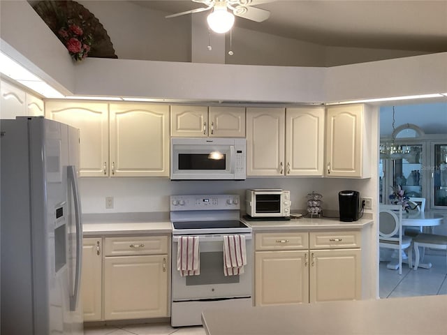 kitchen with light tile patterned floors, white appliances, vaulted ceiling, and ceiling fan