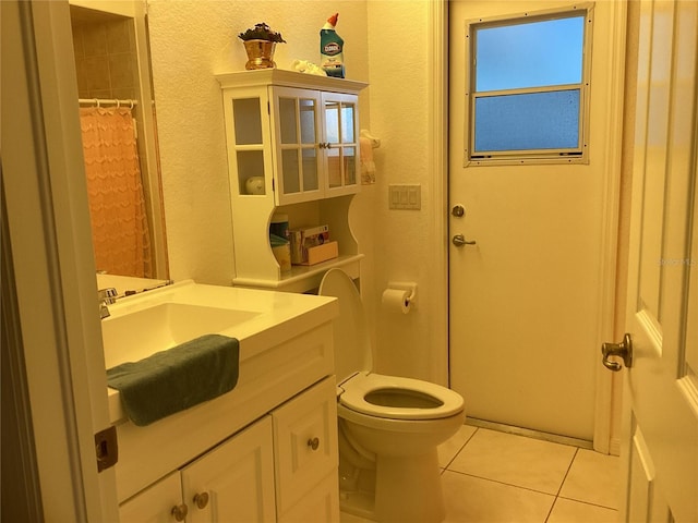 bathroom featuring tile patterned floors, vanity, walk in shower, and toilet