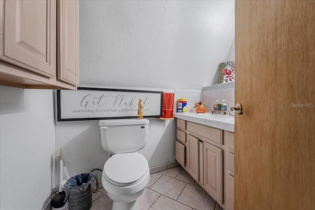 bathroom with tile patterned flooring, vanity, and toilet