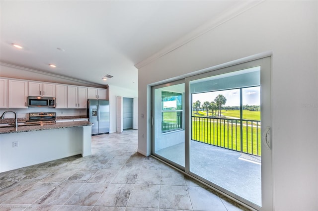 kitchen featuring sink, stainless steel appliances, dark stone counters, lofted ceiling, and ornamental molding