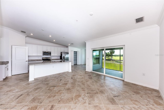 kitchen featuring ornamental molding, stainless steel appliances, a center island with sink, white cabinets, and lofted ceiling