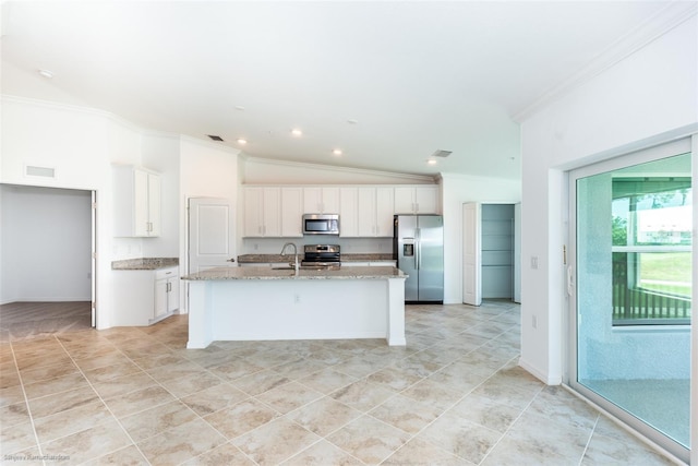 kitchen with crown molding, lofted ceiling, a center island with sink, white cabinets, and appliances with stainless steel finishes