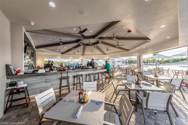 dining area featuring beamed ceiling and ceiling fan