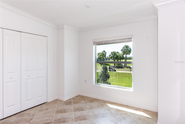 unfurnished bedroom with multiple windows, crown molding, and a closet