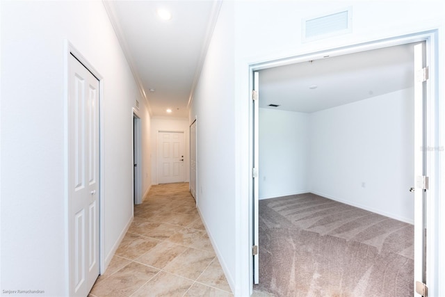 corridor featuring light colored carpet and ornamental molding