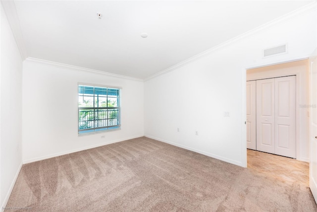 spare room featuring light colored carpet and ornamental molding