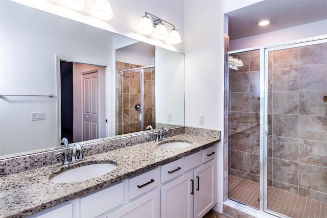 bathroom featuring a shower with door and vanity