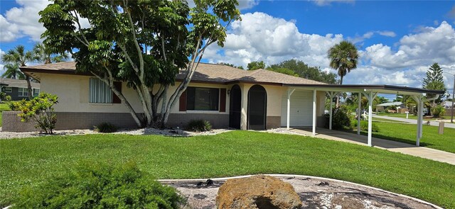 ranch-style house with a front yard, a garage, and a carport