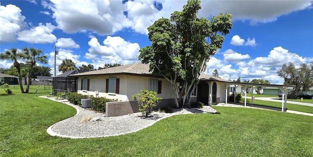 view of front of property featuring glass enclosure, a front lawn, and a carport