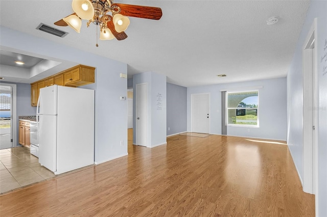 unfurnished living room featuring a textured ceiling, light hardwood / wood-style flooring, and ceiling fan