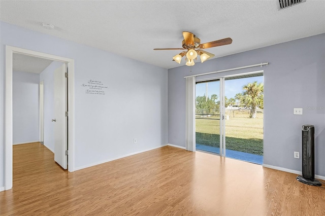 spare room with ceiling fan, a textured ceiling, and light hardwood / wood-style flooring