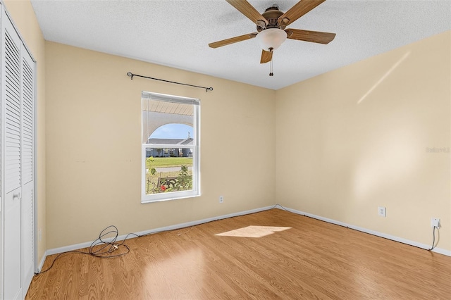 unfurnished bedroom featuring a closet, ceiling fan, light hardwood / wood-style flooring, and a textured ceiling