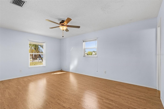 spare room with a textured ceiling, light hardwood / wood-style floors, and ceiling fan