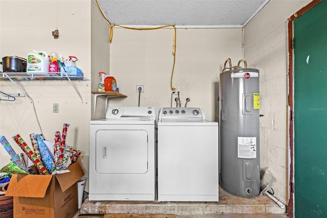 washroom featuring electric water heater, a textured ceiling, and washing machine and clothes dryer