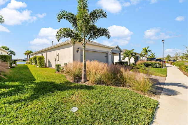 view of side of property featuring a yard and a garage