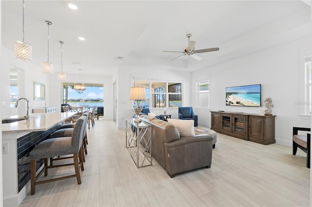 living room featuring ceiling fan and sink