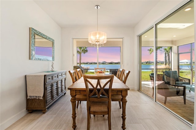 dining area with a notable chandelier and a water view