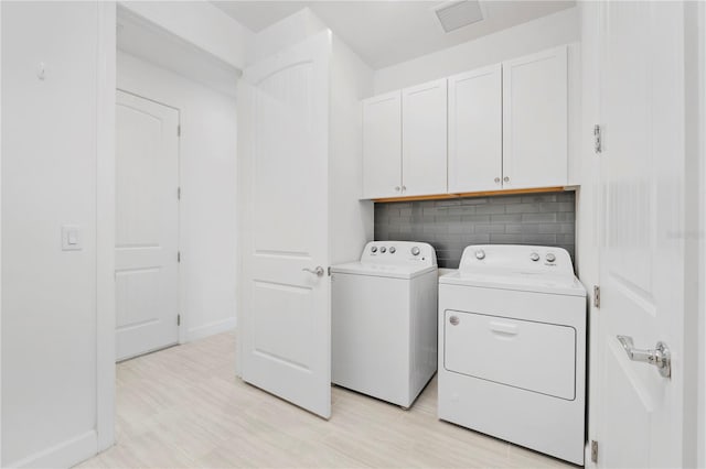 laundry room featuring cabinets and washer and dryer