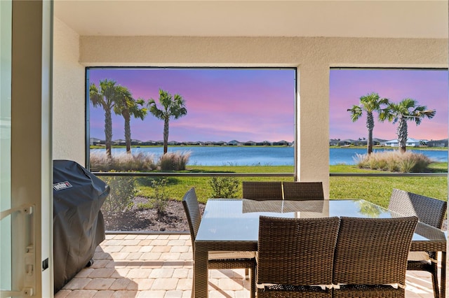 sunroom featuring a water view