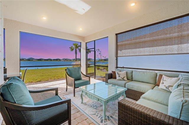 sunroom / solarium featuring a water view