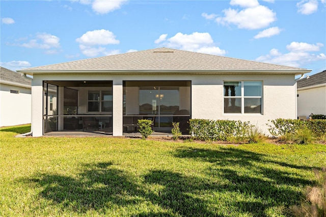 rear view of house featuring a lawn and a sunroom