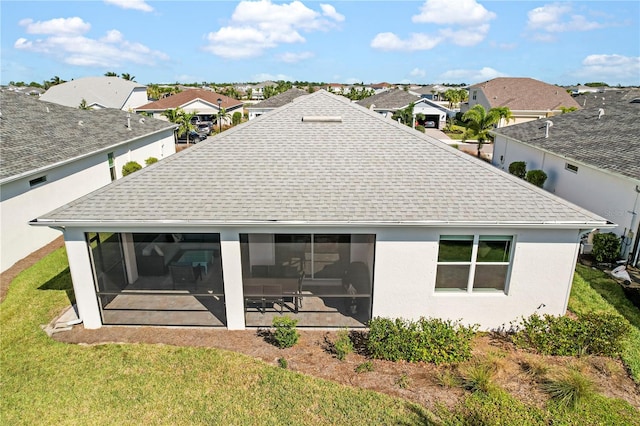 rear view of house with a lawn and a sunroom