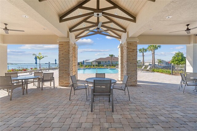 view of patio / terrace featuring ceiling fan, a community pool, and a water view