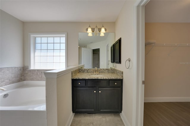 bathroom featuring vanity, a relaxing tiled tub, and wood-type flooring