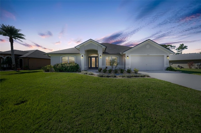 single story home featuring a lawn and a garage