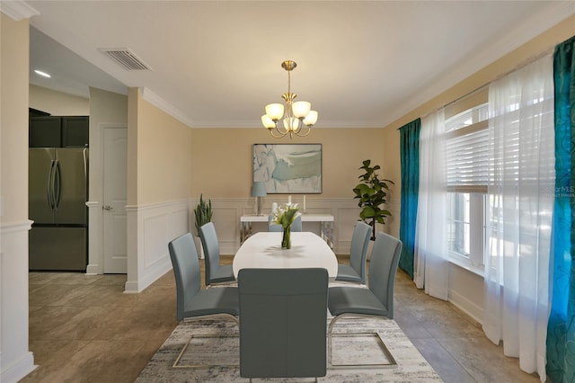 dining space featuring light tile patterned floors, crown molding, and a notable chandelier