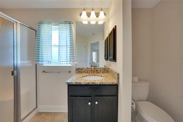 bathroom with tile patterned floors, vanity, toilet, and walk in shower