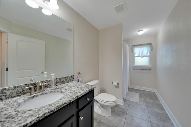 bathroom with tile patterned floors, walk in shower, vanity, and toilet