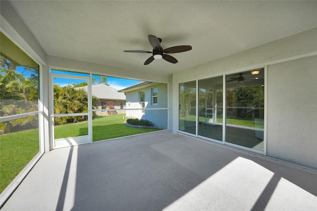 unfurnished sunroom with ceiling fan and plenty of natural light