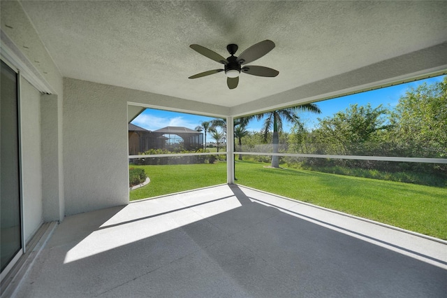 unfurnished sunroom with ceiling fan