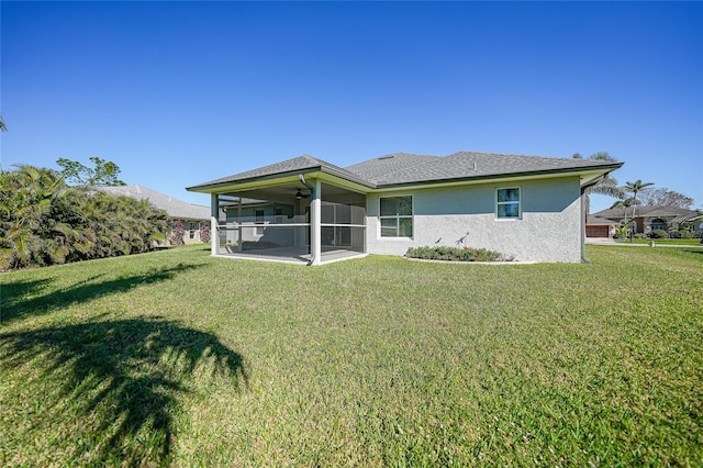 back of property with a sunroom and a lawn