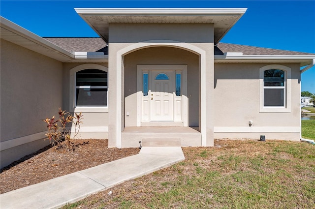 entrance to property featuring a lawn