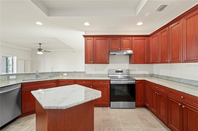 kitchen featuring ceiling fan, sink, stainless steel appliances, and a tray ceiling