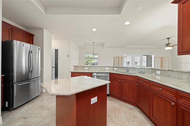 kitchen with sink, ceiling fan, light stone countertops, kitchen peninsula, and stainless steel appliances