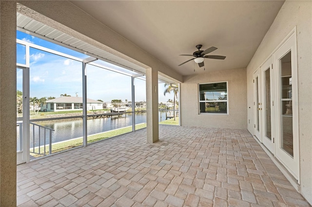 view of patio with ceiling fan, a water view, and french doors