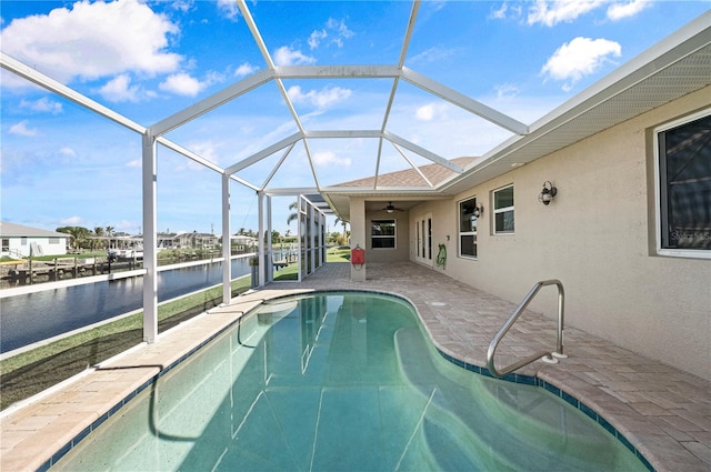 view of pool with a lanai, a patio area, and a water view