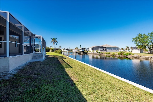 view of yard featuring a water view and glass enclosure