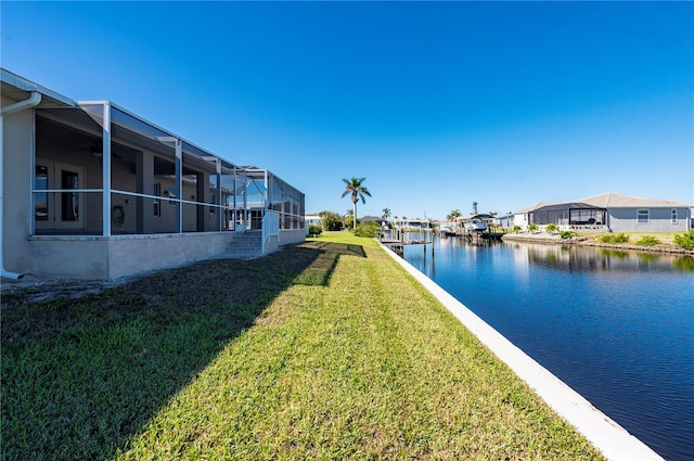 view of yard with glass enclosure and a water view