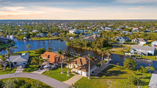 aerial view at dusk featuring a water view