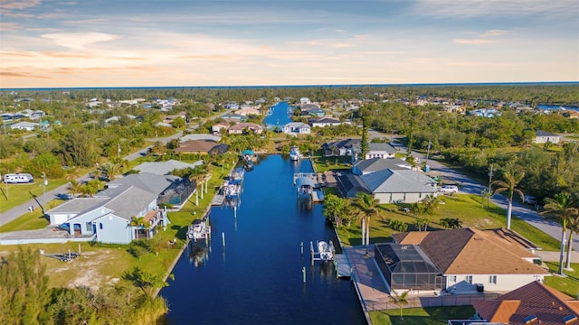 aerial view at dusk featuring a water view