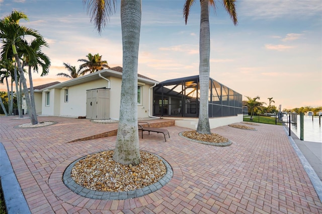 exterior space featuring a patio area, a sunroom, and glass enclosure