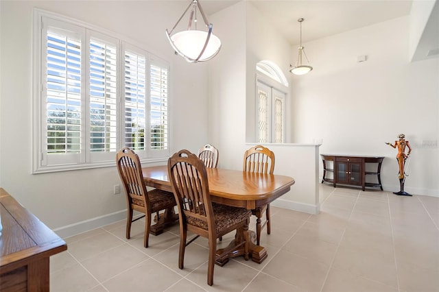 tiled dining room featuring vaulted ceiling