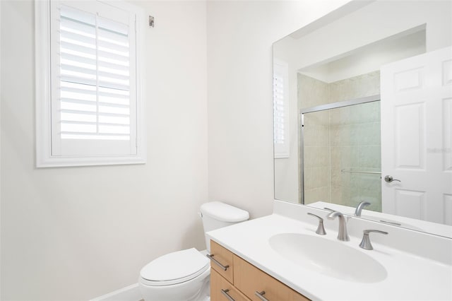 bathroom with vanity, a shower with shower door, and toilet